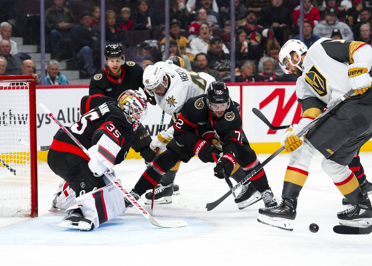 Ottawa Senators goaltender Linus Ullmark (35) and Thomas Chabot (72) watch the puck as they bat ...