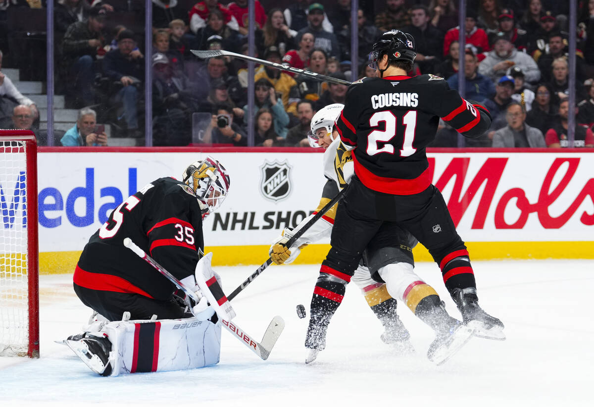 Ottawa Senators goaltender Linus Ullmark (35) makes a save as Senators center Nick Cousins (21) ...