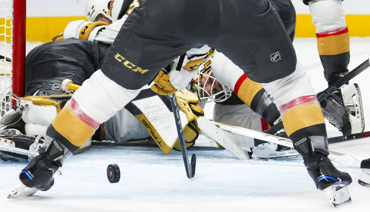 Vegas Golden Knights goaltender Ilya Samsonov, bottom, watches the puck as players pile onto of ...