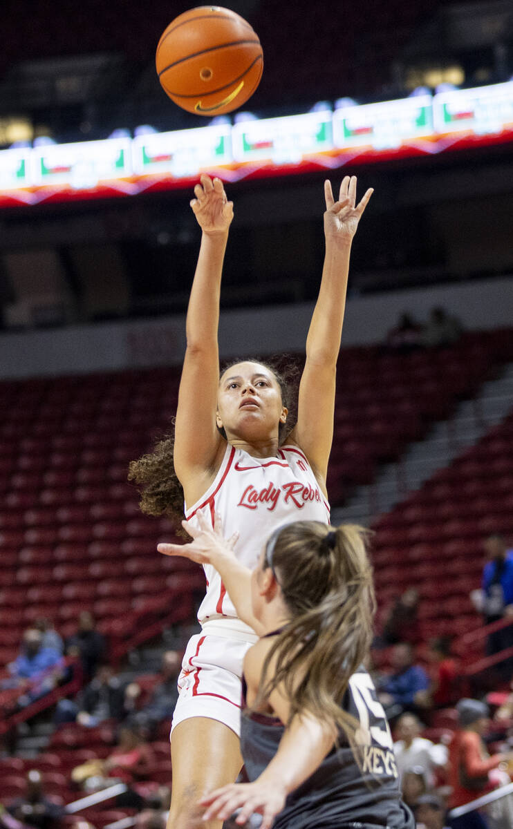 UNLV guard Kiara Jackson, center, attempts a shot during the college basketball game against th ...