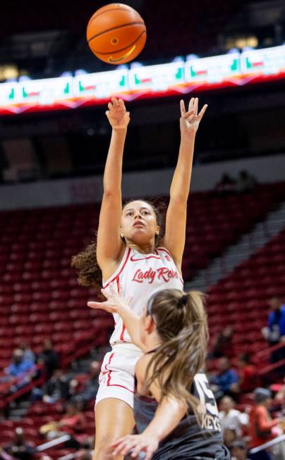 UNLV guard Kiara Jackson, center, attempts a shot during the college basketball game against th ...