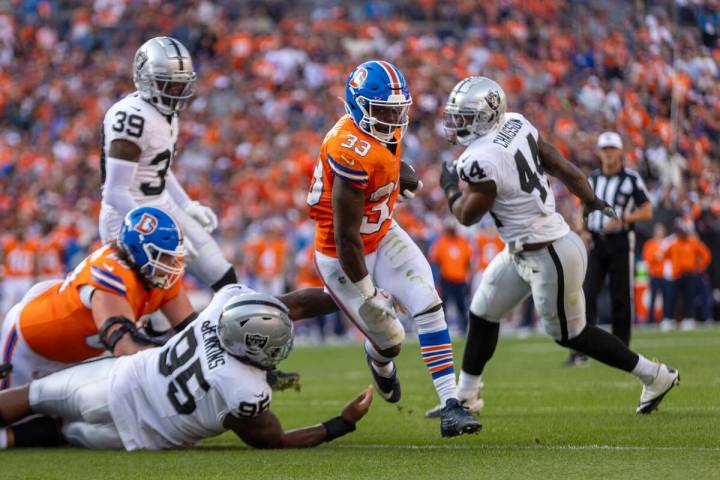 Denver Broncos running back Javonte Williams (33) rushes towards the end zone as Raiders defens ...