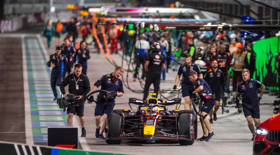 Red Bull Racing driver Sergio Perez awaits help from his pit crew after a stall during the thir ...