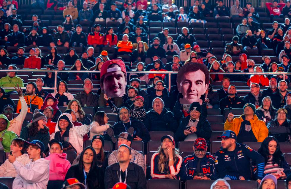 Fans hold up cutouts of Ferrari driver Carlos Sainz and Red Bull Racing driver Sergio Perez dur ...