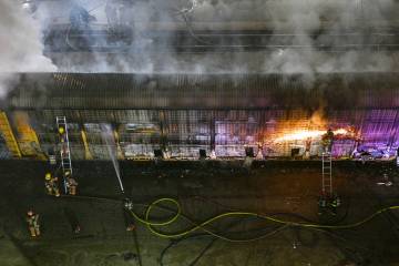 Firefighters work to put out a fire in a railcar carrying autos Friday, November 22, 2024, near ...