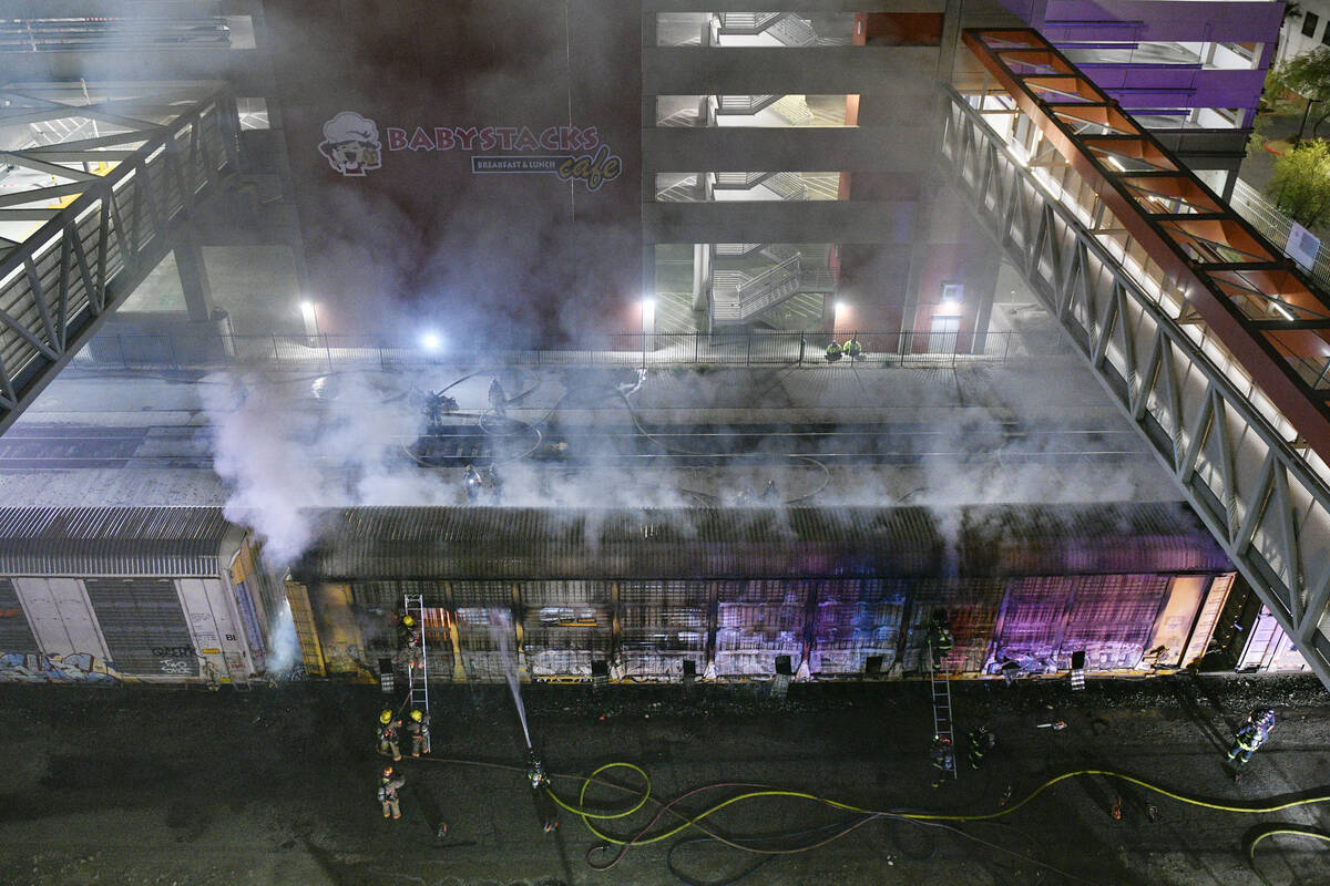 Firefighters work to put out a fire in a railcar carrying autos Friday, November 22, 2024, near ...