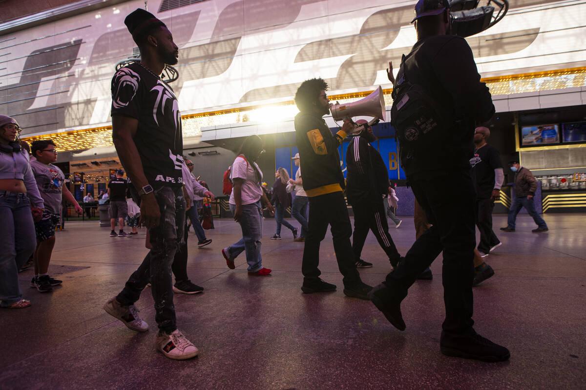 Quentin Savwoir, president of the NAACP Las Vegas branch, chants as people march along the Frem ...