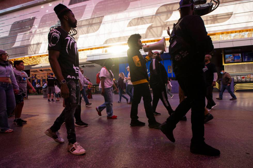 Quentin Savwoir, president of the NAACP Las Vegas branch, chants as people march along the Frem ...