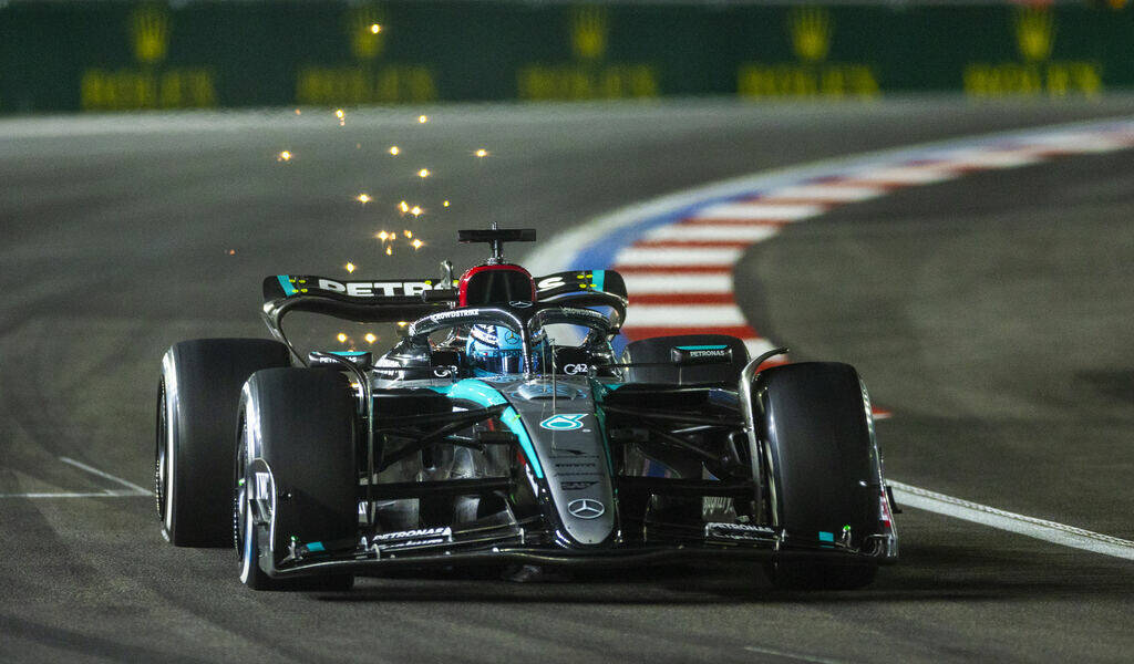 Mercedes driver George Russell sends some sparks flying while in the final turn on the track du ...