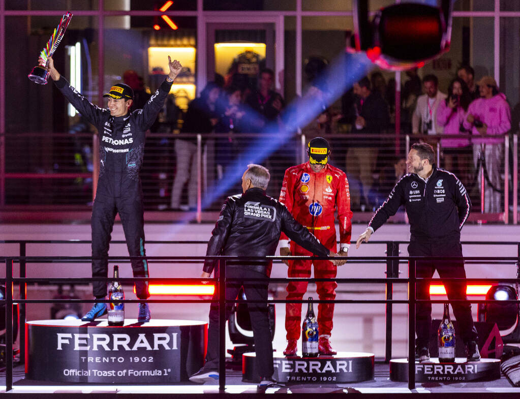 Mercedes driver George Russell celebrates his race win and trophy atop the podium during the Fo ...