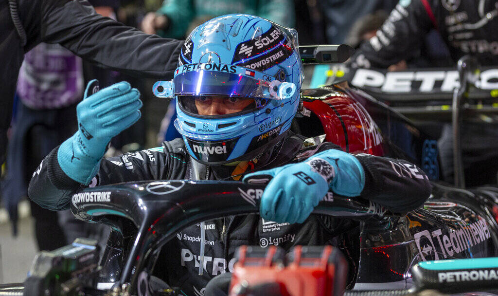 Mercedes driver George Russell signals a technician while in his car before the start during th ...