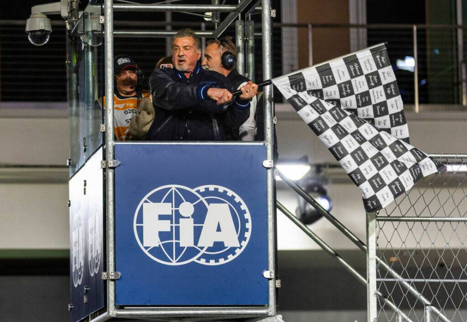 Actor Sylvester Stallone waves the checkered flag at the finish line as the race concludes at t ...