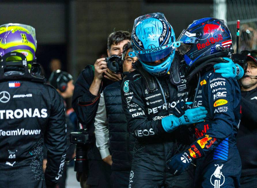 Mercedes driver George Russell hugs Red Bull Racing driver Max Verstappen as Russell wins the r ...