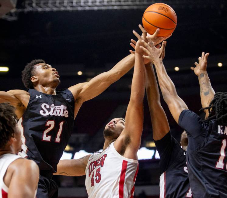 UNLV forward Jeremiah Cherry (45) attempts to rebound the ball from a pack of New Mexico State ...