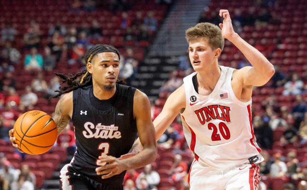 UNLV guard Julian Rishwain (20) guards New Mexico State Aggies guard Christian Cook (3) during ...