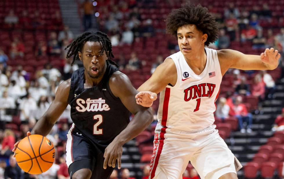 UNLV forward Jalen Hill (1) guards New Mexico State Aggies guard Zawdie Jackson (2) during the ...