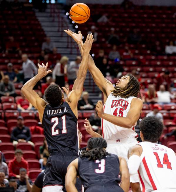 UNLV forward Jeremiah Cherry (45) and New Mexico State Aggies forward Robert Carpenter (21) com ...