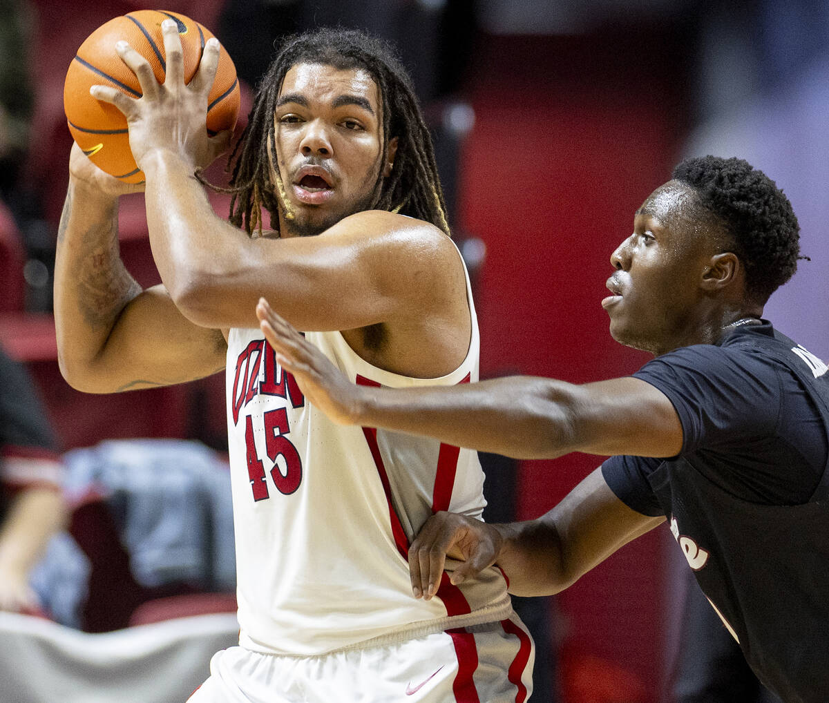 UNLV forward Jeremiah Cherry (45) is guarded by New Mexico State Aggies forward Nate Tshimanga, ...