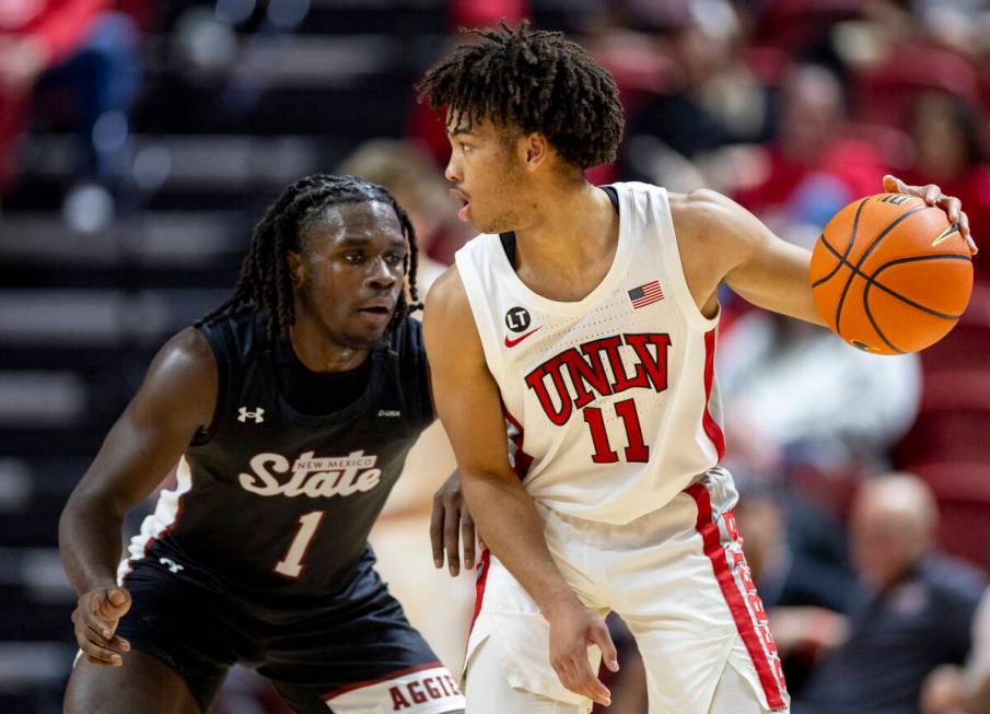 UNLV guard Dedan Thomas Jr. (11) looks to make a play against New Mexico State Aggies guard Gab ...