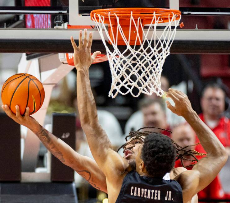 UNLV forward Jeremiah Cherry attempts a layup while in coverage during the college basketball g ...