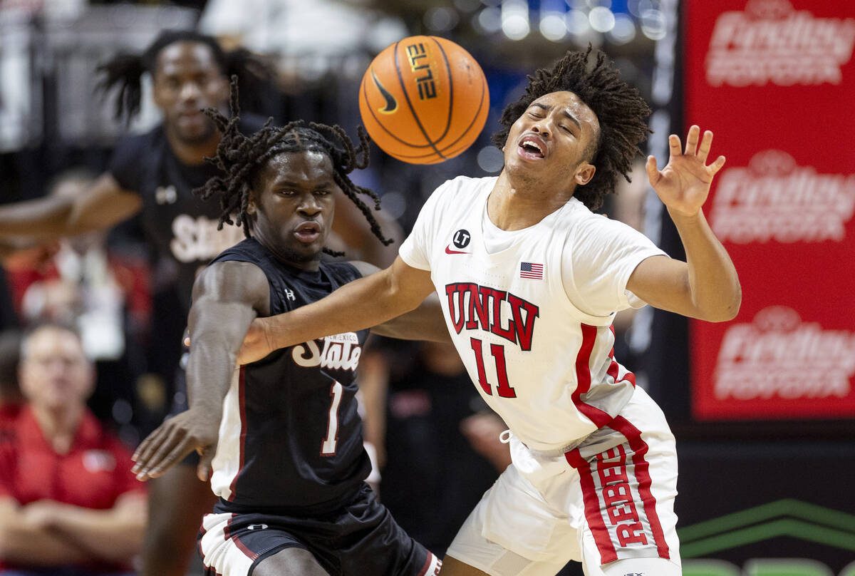 UNLV guard Dedan Thomas Jr. (11) is fouled by New Mexico State Aggies guard Gabe Pickens (1) du ...