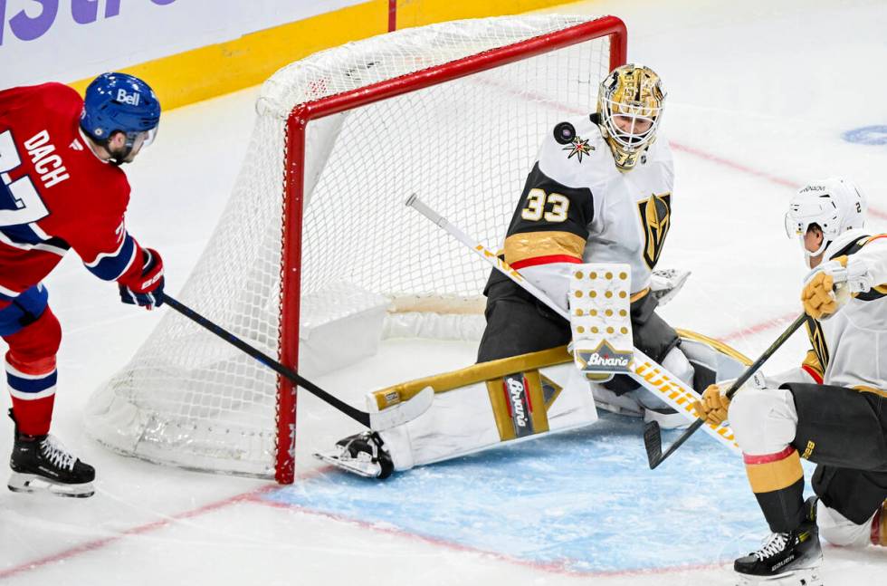 Montreal Canadiens' Kirby Dach (77) moves in on Vegas Golden Knights goaltender Adin Hill (33) ...