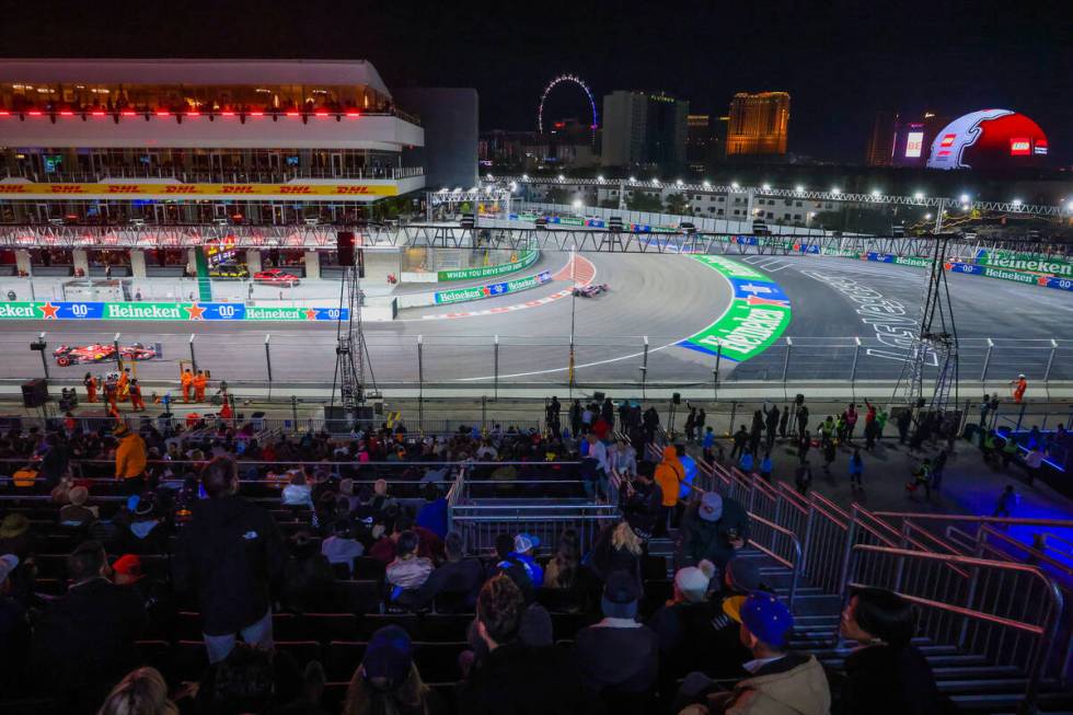 Fans sit in the grandstands as drivers zoom by during Formula 1 opening practice ahead of the F ...