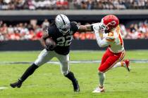 Raiders running back Alexander Mattison (22) fends off Kansas City Chiefs safety Nazeeh Johnson ...