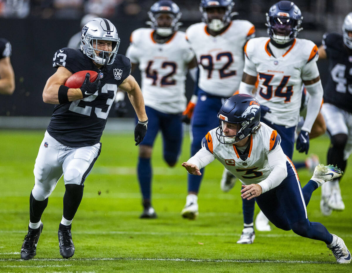 Raiders running back Dylan Laube (23) nearly gets past Denver Broncos place kicker Wil Lutz (3) ...