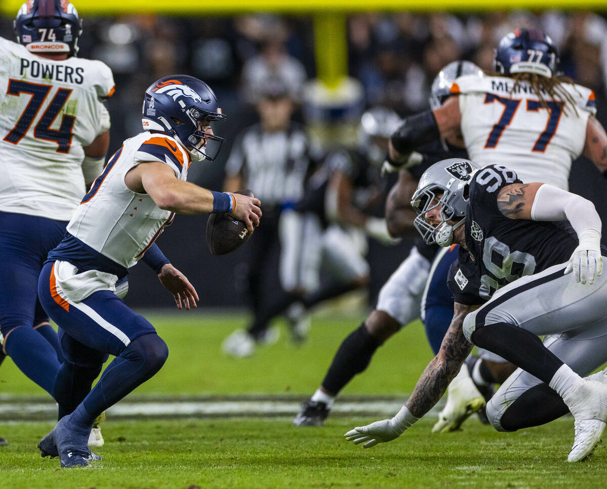 Raiders defensive end Maxx Crosby (98) cuts off Denver Broncos quarterback Bo Nix (10) causing ...