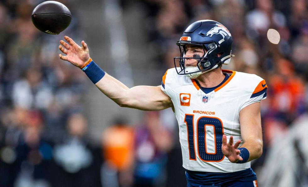 Denver Broncos quarterback Bo Nix (10) gets off a pass against the Raiders during the first hal ...