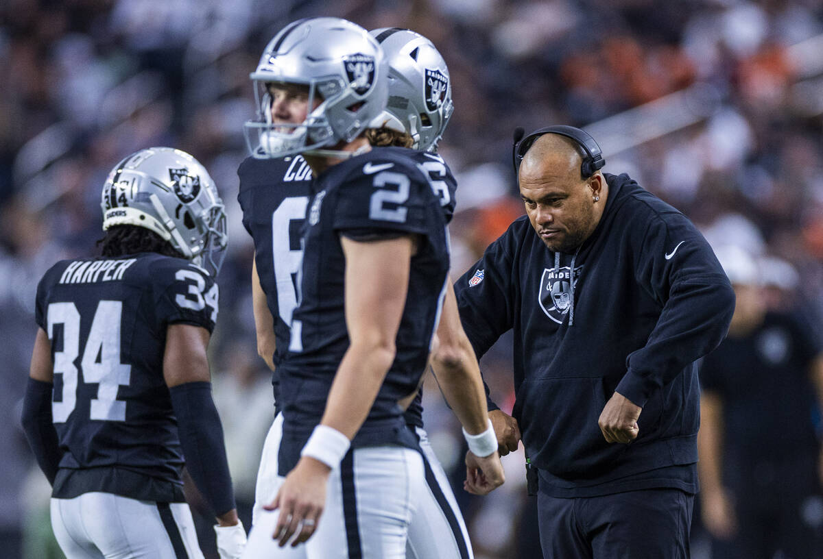 Raiders head coach Antonio Pierce flexes with Raiders punter AJ Cole (6) after another successf ...