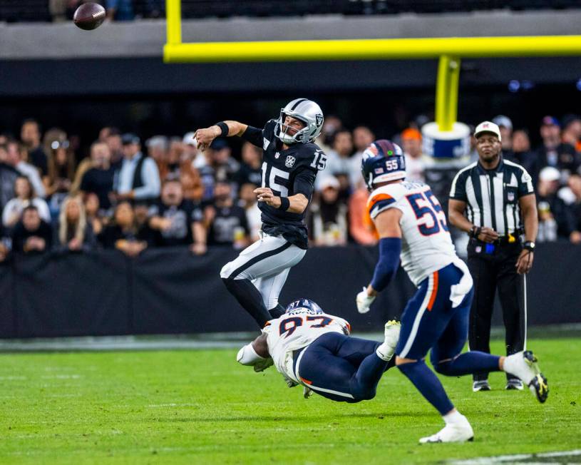 Raiders quarterback Gardner Minshew (15) gets rid of the ball on a scramble as Denver Broncos d ...