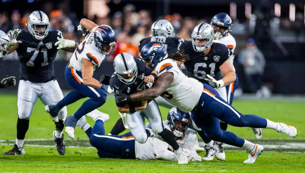 Raiders quarterback Gardner Minshew (15) is taken down by Denver Broncos defensive end Eyioma U ...