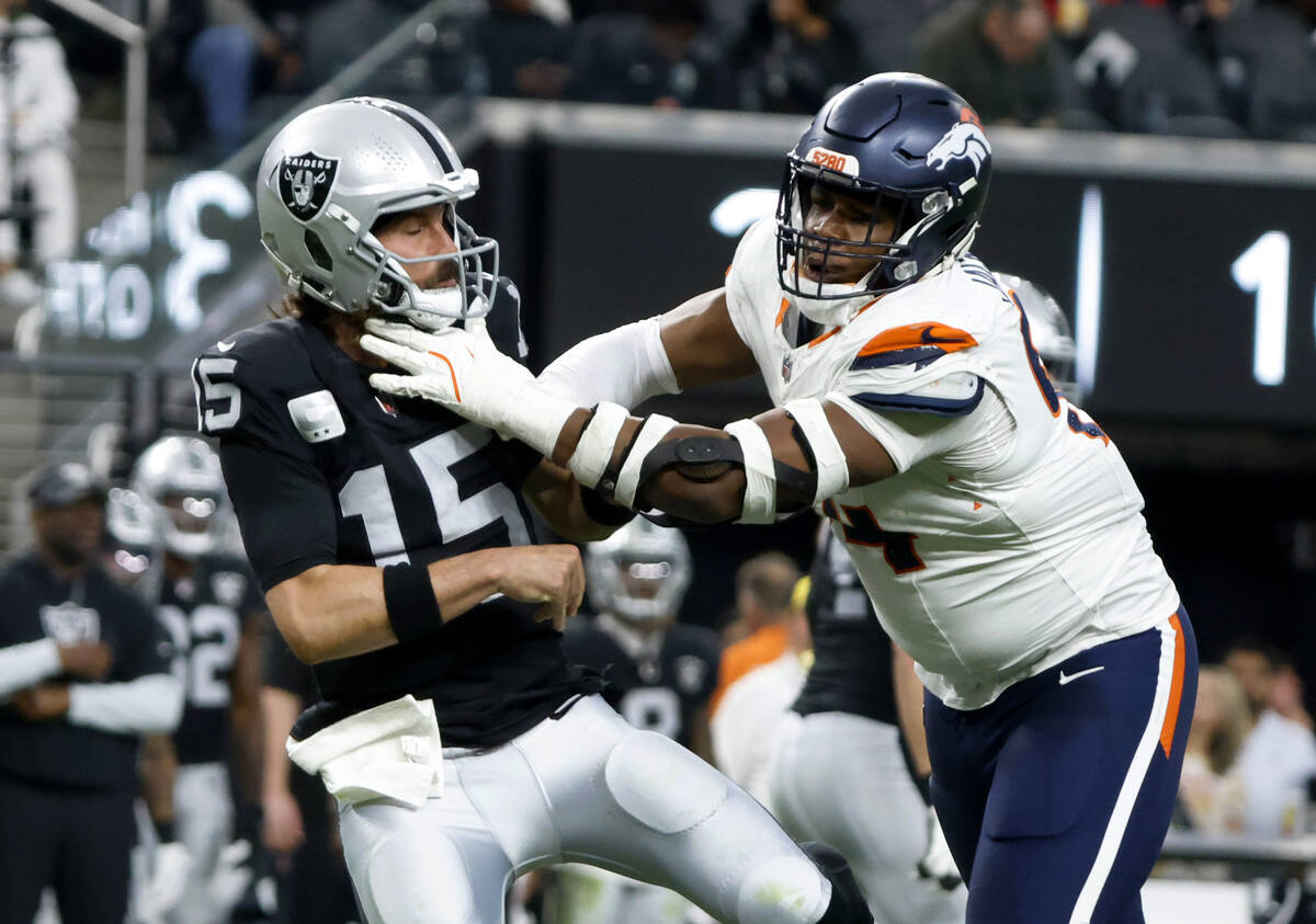 Raiders quarterback Gardner Minshew (15) throws under pressure from Denver Broncos defensive ta ...