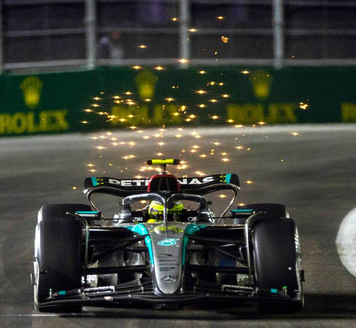 Mercedes driver Lewis Hamilton sends some sparks flying while in the final turn on the track du ...