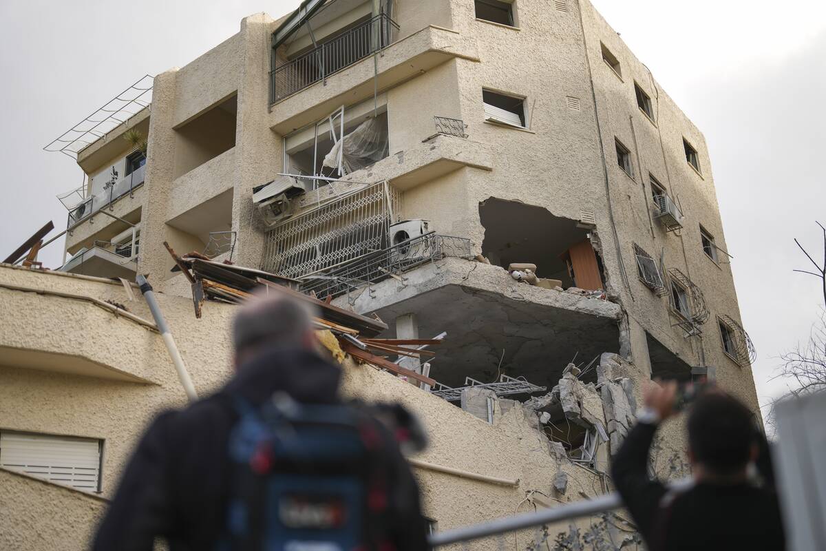 Journalists take pictures of a building hit direct by a rocket fired from Lebanon in Haifa, Isr ...