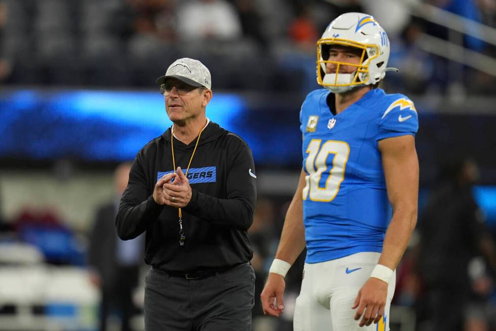 Los Angeles Chargers head coach Jim Harbaugh talks with quarterback Justin Herbert before an NF ...