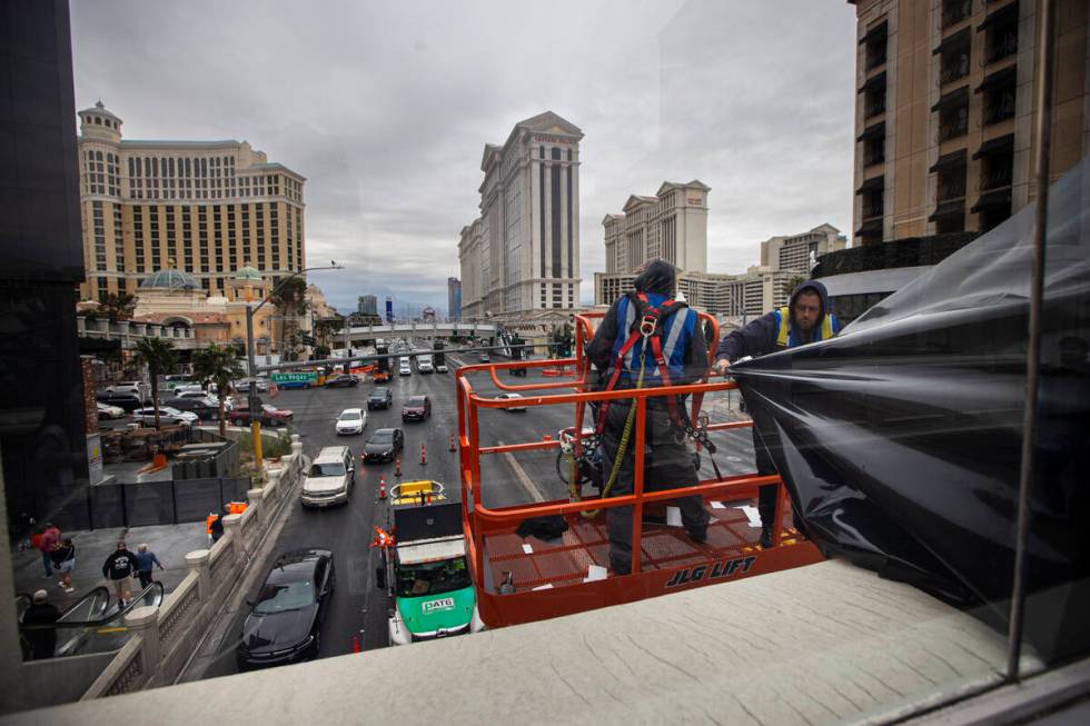 A crew removes film that previously blocked the view from a pedestrian bridge following the For ...