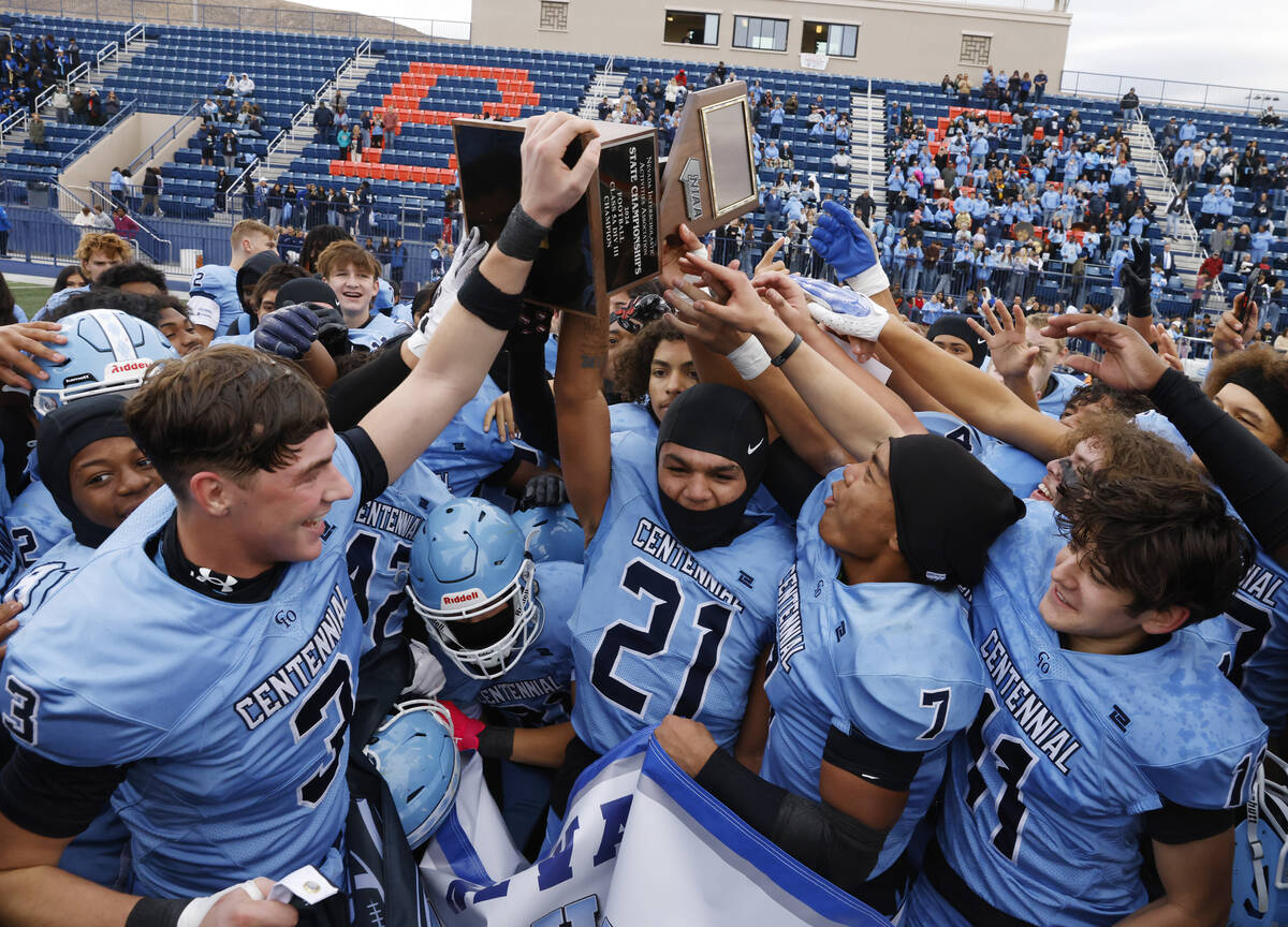 Centennial High players celebrate their Class 5A Division III football state championship win a ...