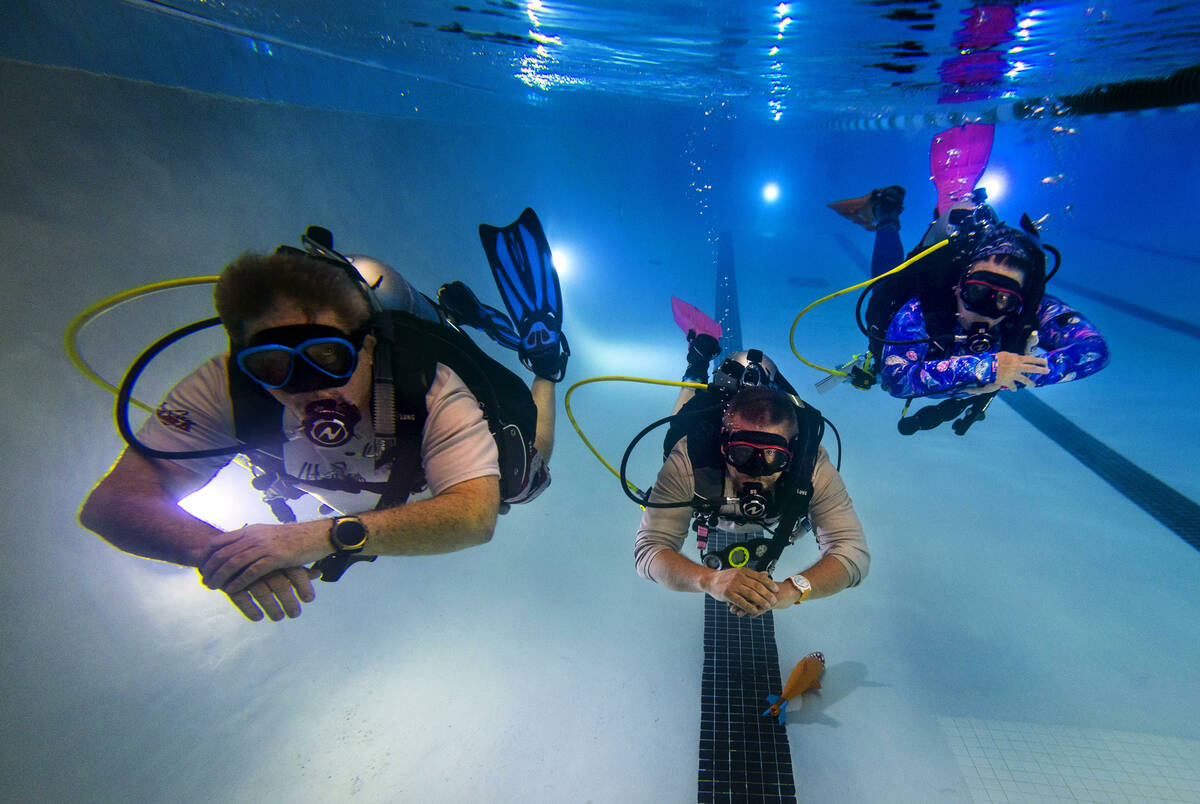 Sin City Scuba members, from left, Curtis Snaper, John Sivia and Erin Sivia demonstrate underwa ...