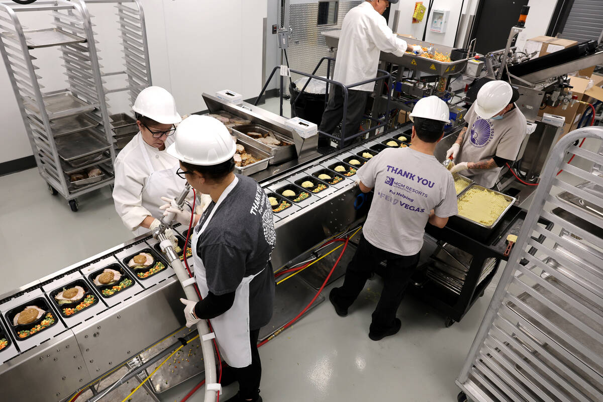 Workers make meals for the Meals on Wheels program at Catholic Charities of Southern Nevada in ...