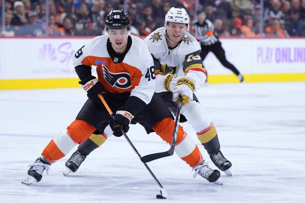 Philadelphia Flyers' Morgan Frost, left, tries to keep the puck away from Vegas Golden Knights' ...