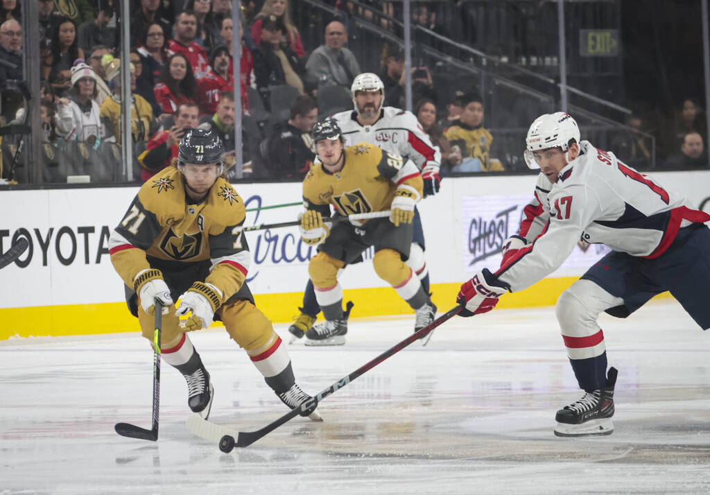 Washington Capitals center Dylan Strome (17) steals the puck from Golden Knights center William ...