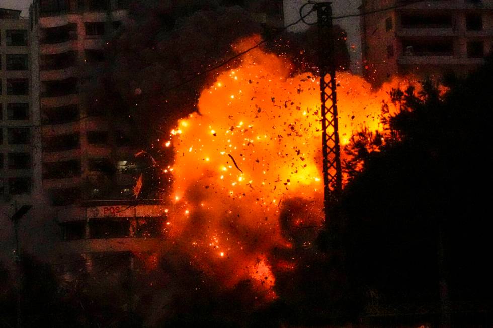 Flames and debris erupt from an Israeli airstrike that targeted a building in Tayouneh, Beirut, ...