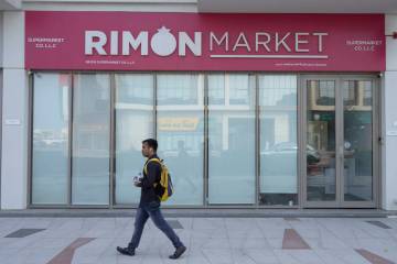 A man walks past Rimon Market, a Kosher grocery store managed by the late Rabbi Zvi Kogan, in D ...