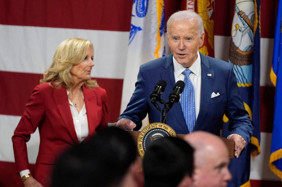 President Joe Biden speaks as first lady Jill Biden looks on at a Friendsgiving event with serv ...