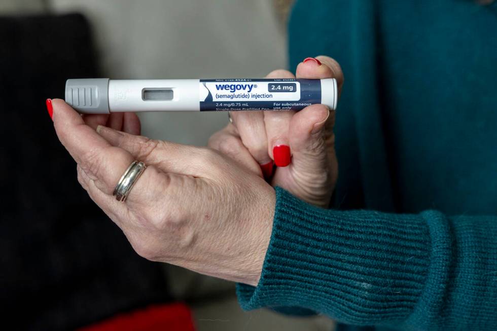 Donna Cooper holds up a dosage of Wegovy, a drug used for weight loss, at her home, March 1, 20 ...