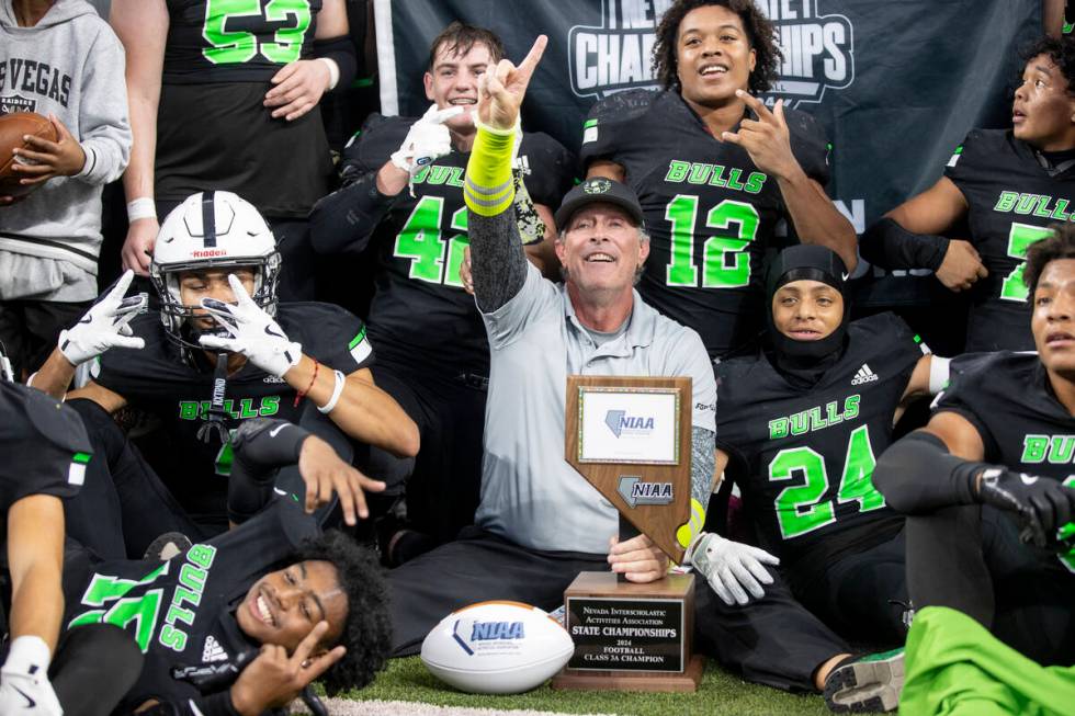 SLAM Academy Head Coach Mike Cofer celebrates with the team after winning the Class 3A football ...