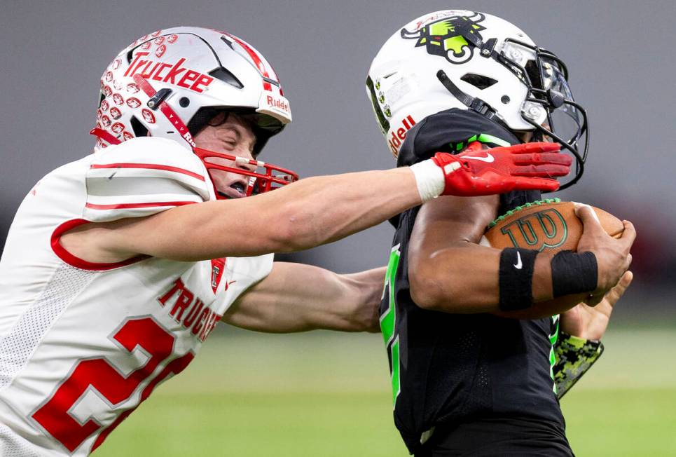 Truckee senior Chase Rothery, left, attempts to tackle SLAM Academy junior Alaijah Young, right ...